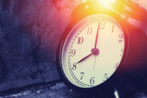8 o'clock vintage clock at dark color tone with sun light memory time concept Stock Photos