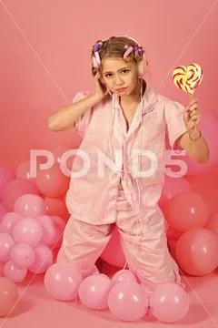 8 or 9 years old child girl eating big multicolor spiral lollipop Stock Photos