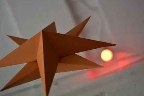 8 point paper star with a red light behind it Stock Photos
