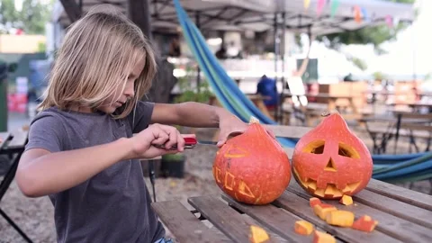8 year old boy carving Halloween pumpkin Stock Footage 208651348