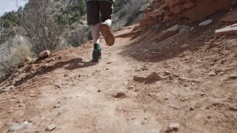 8 year old boy runs along desert path in red rock mountains of Escalante Utah Stock Footage 248581293