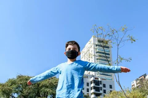 8 year old child with open arms on a sunny day in the public park. Stock Photos