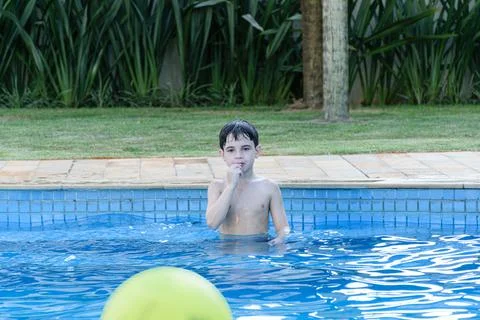 8 year old child in the pool looking apprehensive and biting his nails waitin Stock Photos