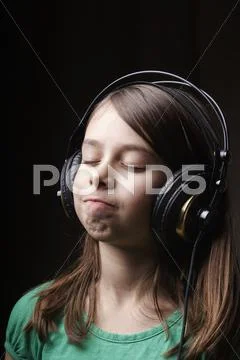 8-Year-Old Girl With Earphones Listening To Music
