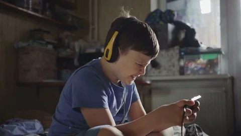 8 years caucasian type boy playing the on the smartphone at home. Stock Footage 82280424