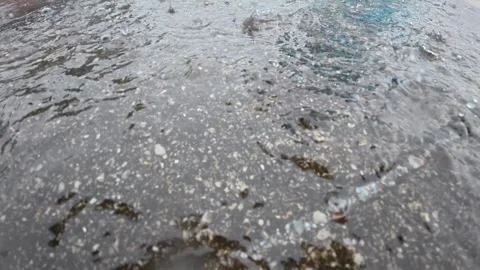 82 Heavy tropical rain drops splashing on puddle over wet pavement Stock Footage 345495046