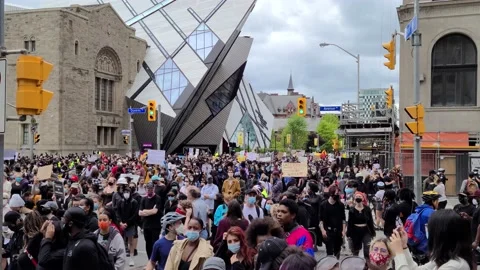 8K - Big group of demonstrators gathered at street corner on overcast day Video stock 131687465