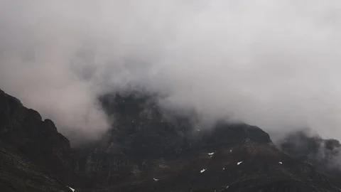 8K Close up of clouds flowing around mountain peaks Video stock 107965723