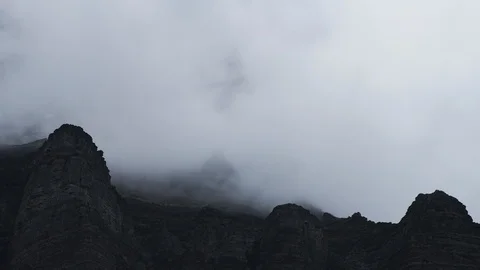 8K Close up of clouds flowing around mountain peaks Video stock 107966699