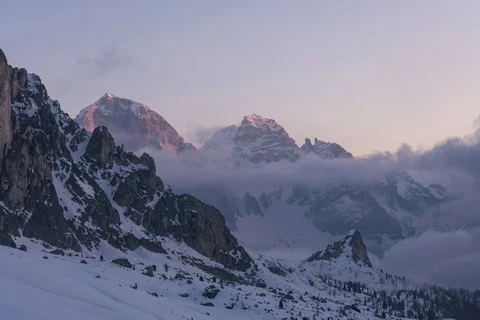8K Dolomites Clouds Rolling In Valley and Sun illuminates the mountains Stock Footage 107849680