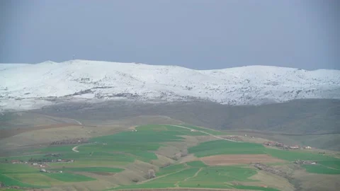 8K Green fields under the snowy hills Stock Footage 171745158
