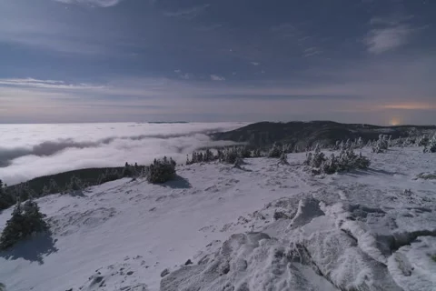 8K Midnight low clouds illuminated by fullmoon rolling in the valley Stock Footage 256146075