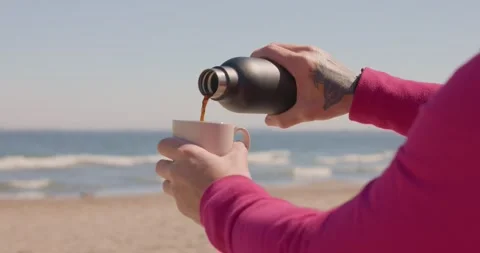 8K pouring coffee on the beach Video stock 240584279