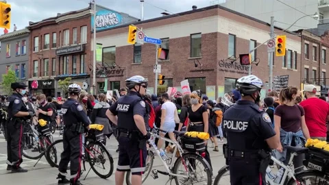 8K - Slow turning motion around cops ensuring safety during protest Stock Footage 131781288
