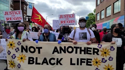 8K - Straight front facing shot of people marching while carrying a banner Video stock 131686100