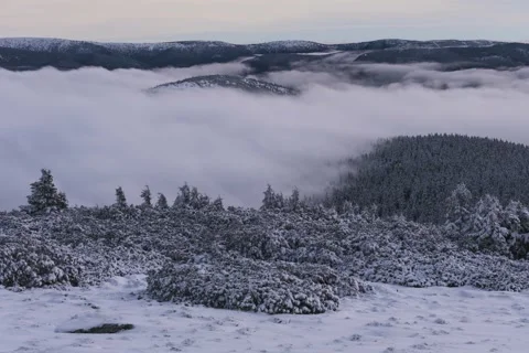 8K Sunset low clouds rolling over the frozen hills Stock Footage 256156679