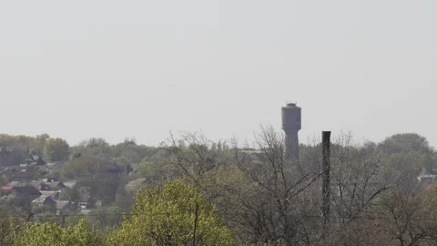 8K Ultra HD: Soviet Era Water Tower Rising Over a Rural Village Landscape. Stock Footage 333977836