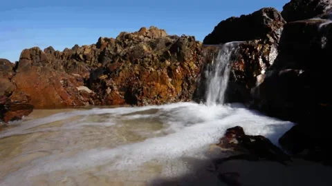 8K vid of a small stream flowing from the ocean waves Stock Footage 222867102