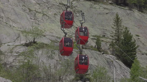 8K video red cable car cabins cross each other in chamonix-mont-blanc valley Stock Footage 222049083
