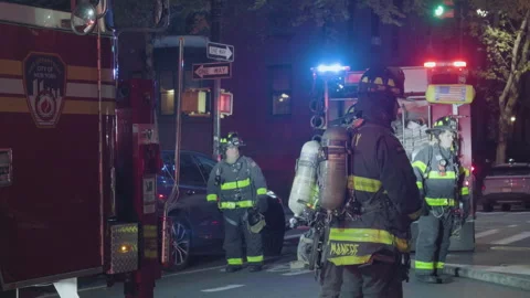 9-20-26, Brooklyn, NY, USA - dusk firemen linger by flashing firetrucks Stock Footage 346107839