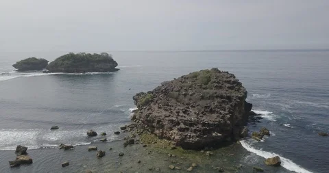 9. aerial view, bird view of a large rock in the middle of the ocean hit by t Stock Footage 121700692
