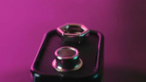 A 9-volt battery rotates and shines in rays of light on a pink background Stock Footage 171039909