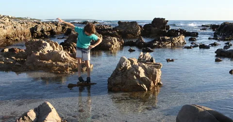 9 year old boy exploring rocky coastline, DeKelders, Western Cape, South Africa Video stock 202532596