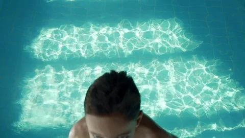 9 year old boy falling into the pool with blue water. Splashes fly in different Stock Footage 106073329