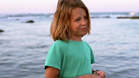 A 9-year-old boy with long hair enthusiastically shares something while standing Video stock 250813808