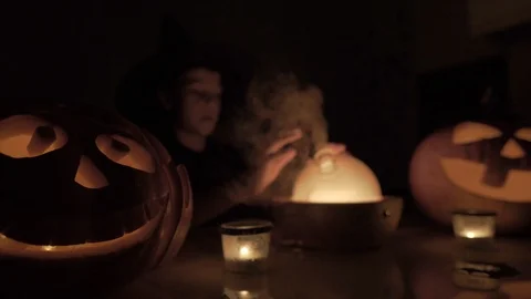 9 year old boy plays wizard on Halloween. With a magic lamp and a pumpkin on the 動画素材 119524615