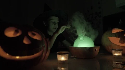 9 year old boy plays wizard on Halloween. With a magic lamp and a pumpkin on the Stock Footage 119524752