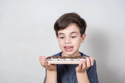 9 year old looking at a tray with several Brazilian fudge balls. Stock Photos