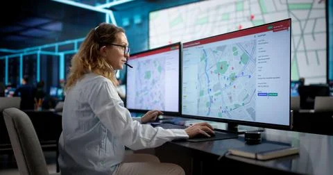 911 Emergency Services: Woman Using Headset To Dispatch Ambulance And Fire. Stock Photos
