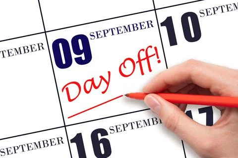 9th day of September. Hand writing text DAY OFF and drawing a line on calenda Stock Photos