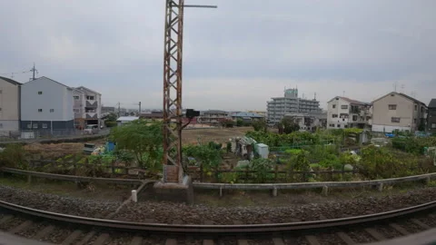 Aa moving train window passing through a suburban landscape in Osaka, Japan Stock Footage 336099533