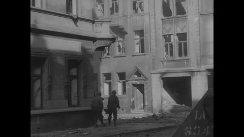 AACHEN - 1944: Corner building view - A figure stands by a scarred corner 库存影片 344005662