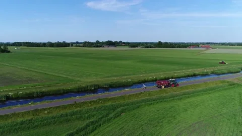 Aaerial view of tractor moving over rural road hauling trailer 4k Stock Footage 150295505