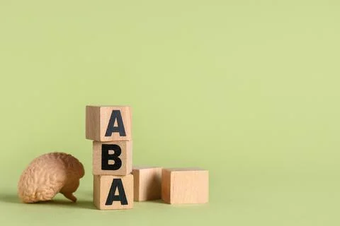 Aba therapy with brain model and wooden blocks on green background for autism Stock Photos