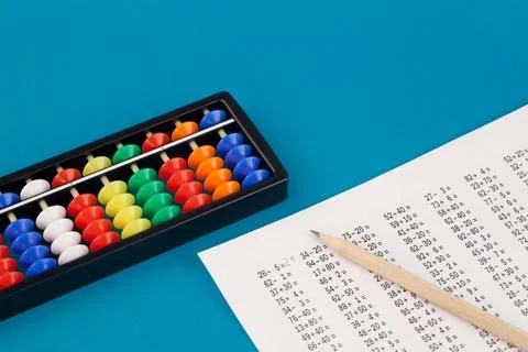 Abacus for mental arithmetic, on a blue background, with examples to solve. Stock Photos