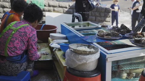 Abalone being prepared to sell with help from a Haenyeo at a small food Stock Footage 130226371