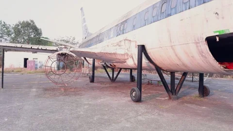 Abandoned airplane with missing engines and overgrown vegetation Stock Footage 266722264