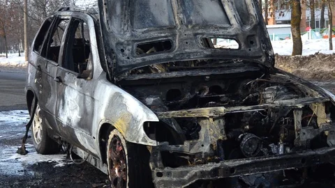 Abandoned and burned down car, left abandoned on side of a street in city Stock Footage 102783928