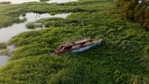 Abandoned and rusting ship in grass on coast Stock Footage 279515145