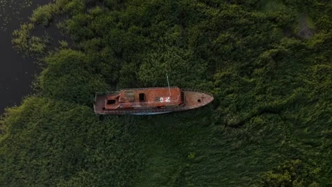 Abandoned and rusting ship in grass on coast Stock Footage 279548053
