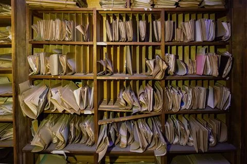 Abandoned archive room. Old documents on shelves Stock Photos
