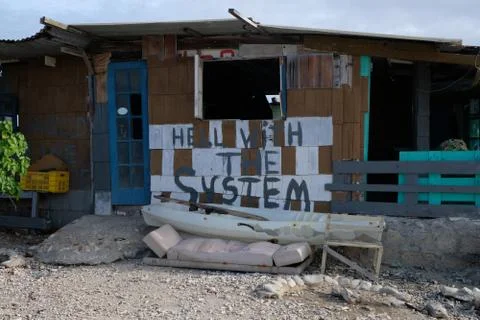 Abandoned beach shack with hell with the system written on it Stock Photos