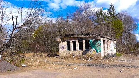 Abandoned brick building with graffiti in a desolate landscape Video stock 347774257