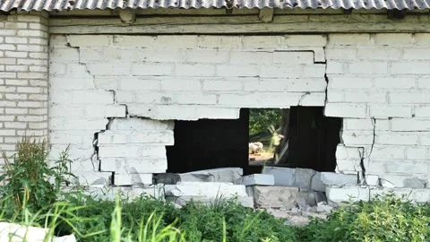 Abandoned brick building with large hole and visible cracks, decaying structure Stock Footage 344697639