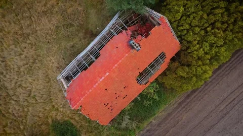Abandoned broken down brick house in the meadow. Severely damaged building after Stock Footage 262335375