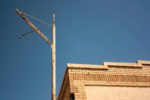 Abandoned Building with Empty Sign Post Against a Blue Sky Stock Photos